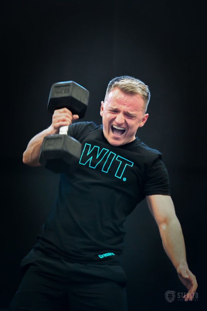 athlete perform dumbbell snatch against dark background