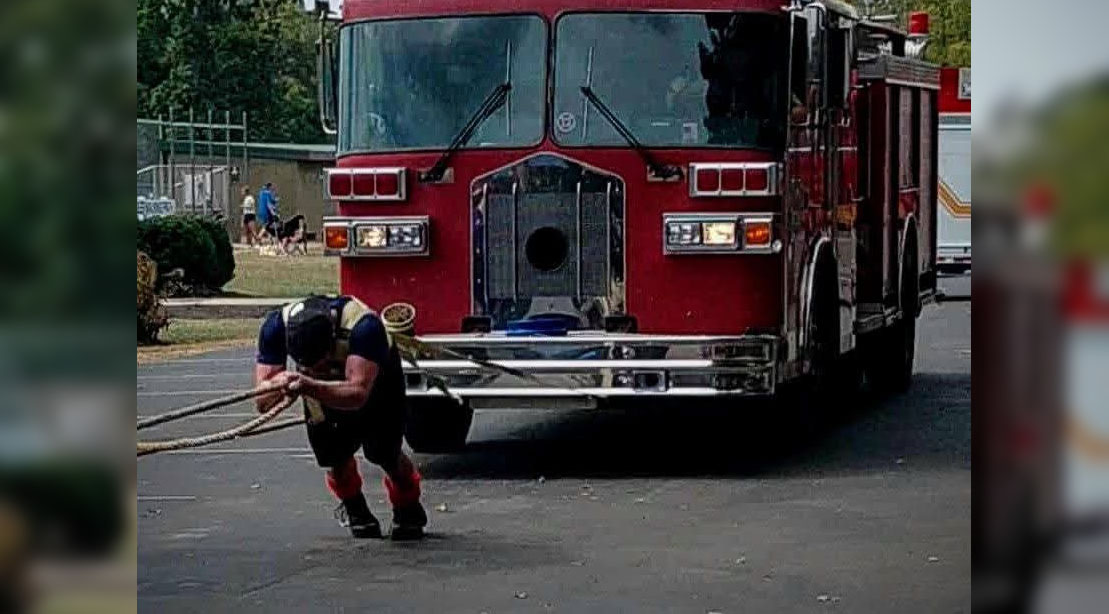 Strongman firefighter Zachary Mills pulling a fire truck