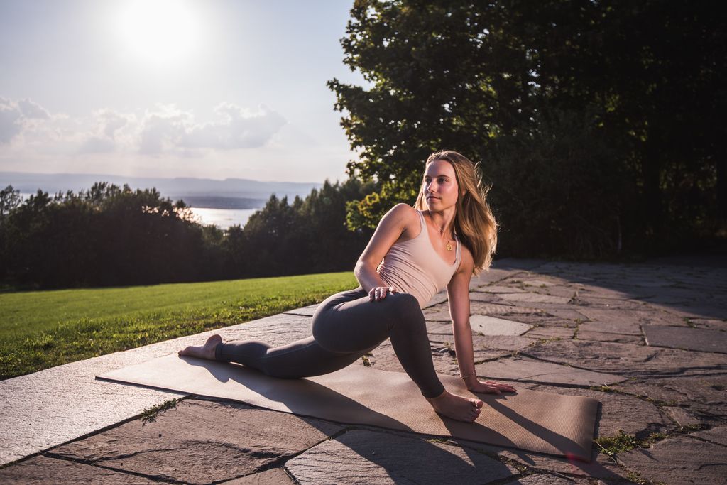 woman doing dragon or lizard yoga pose
