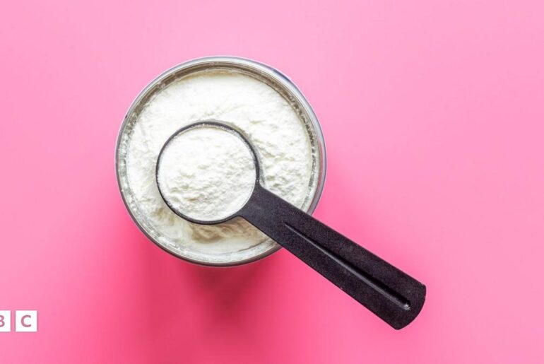 Tub of creatine with a measuring spoon in it which is also filled with creatine