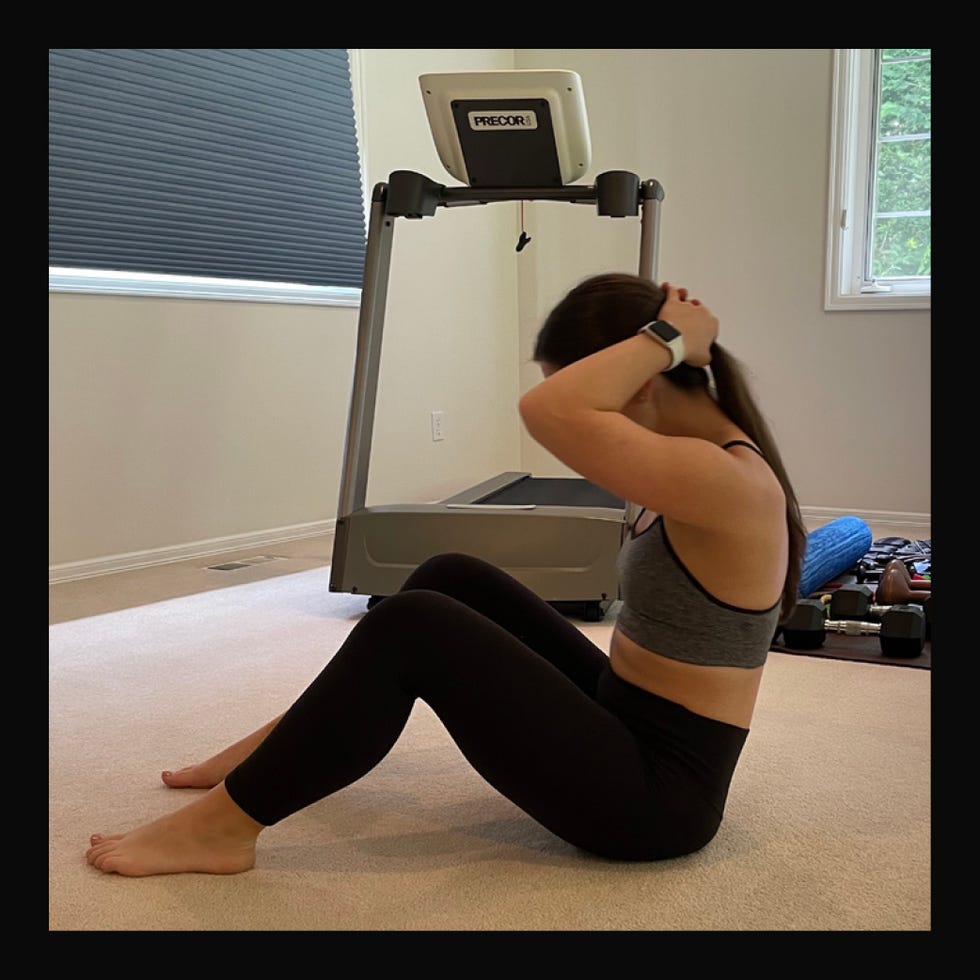woman performing situps in a home workout setting woman performing situps in a home workout setting