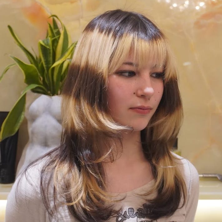 person with layered hair style in a salon setting