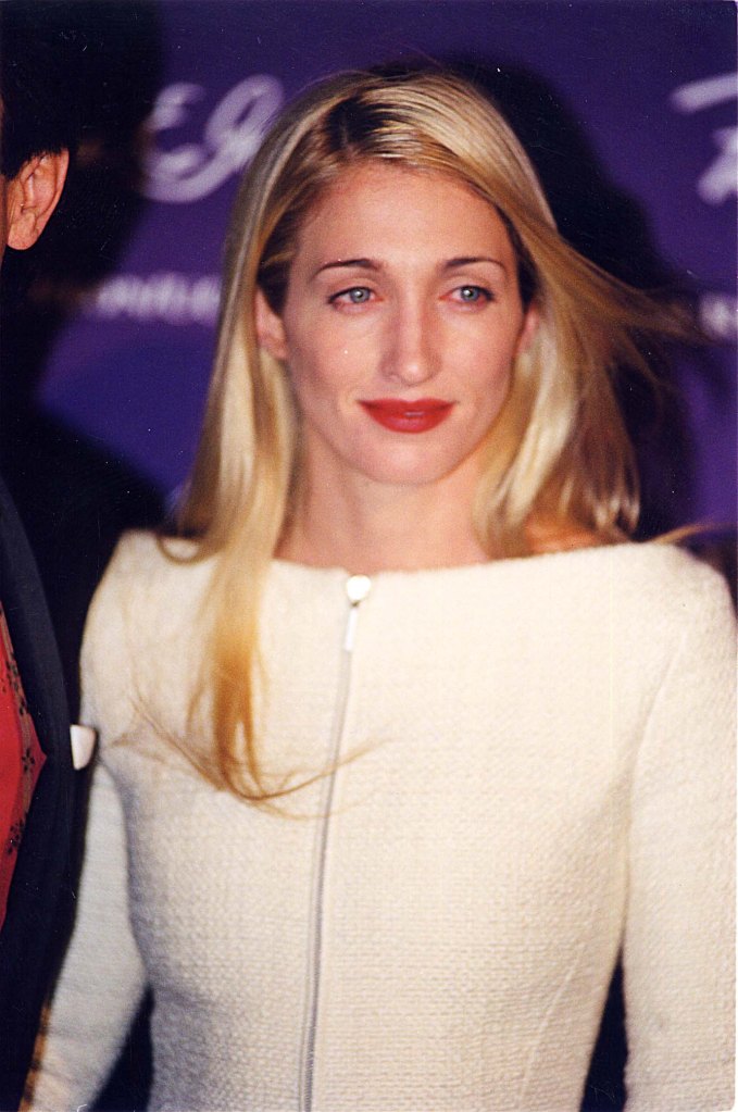 Headshot of Carolyn Bessette at the 1998 Fire & Ice Ball in Los Angeles, wearing red lipstick and a white zippered top.