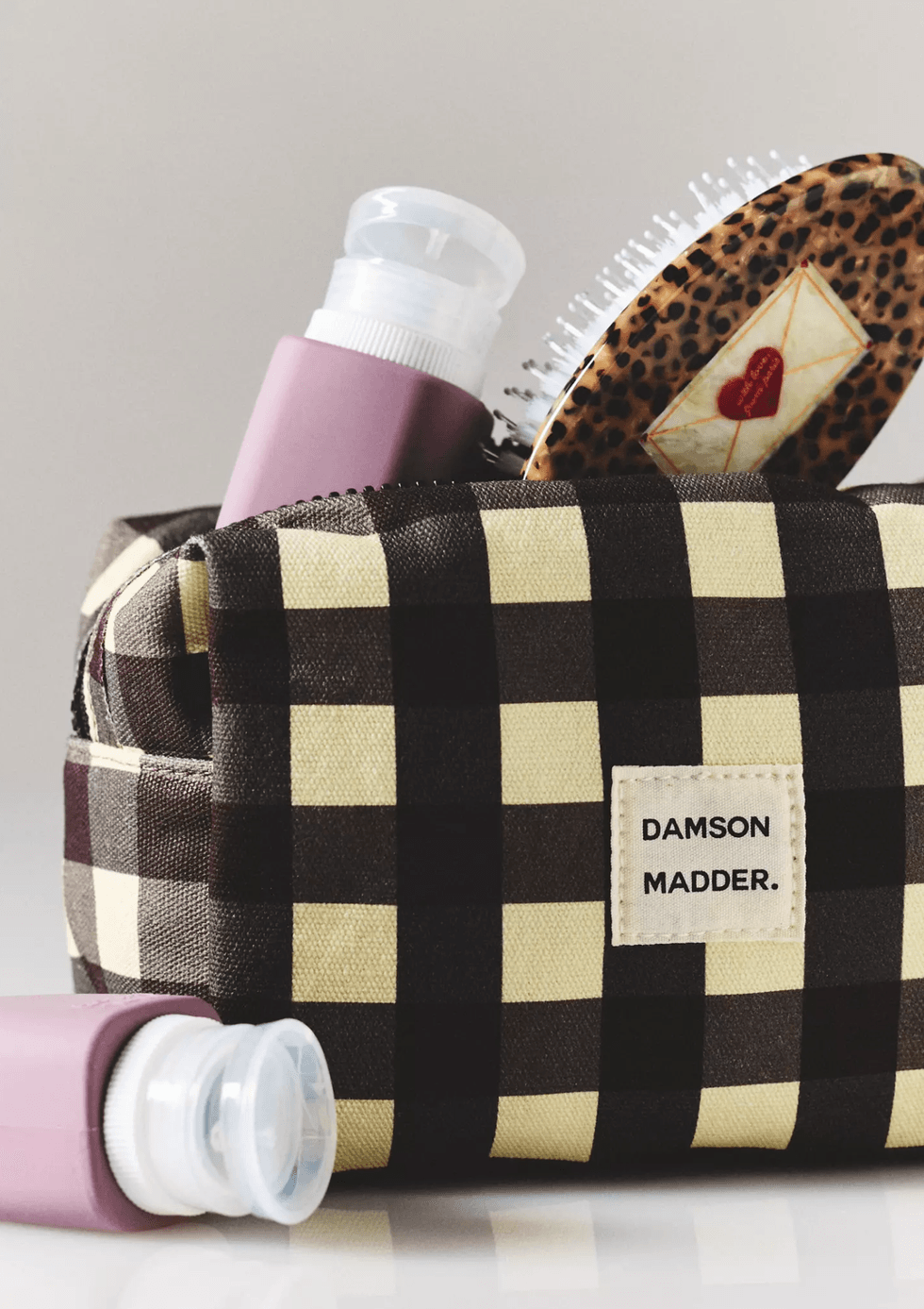 Checkered bag with hairbrush and bottle,
