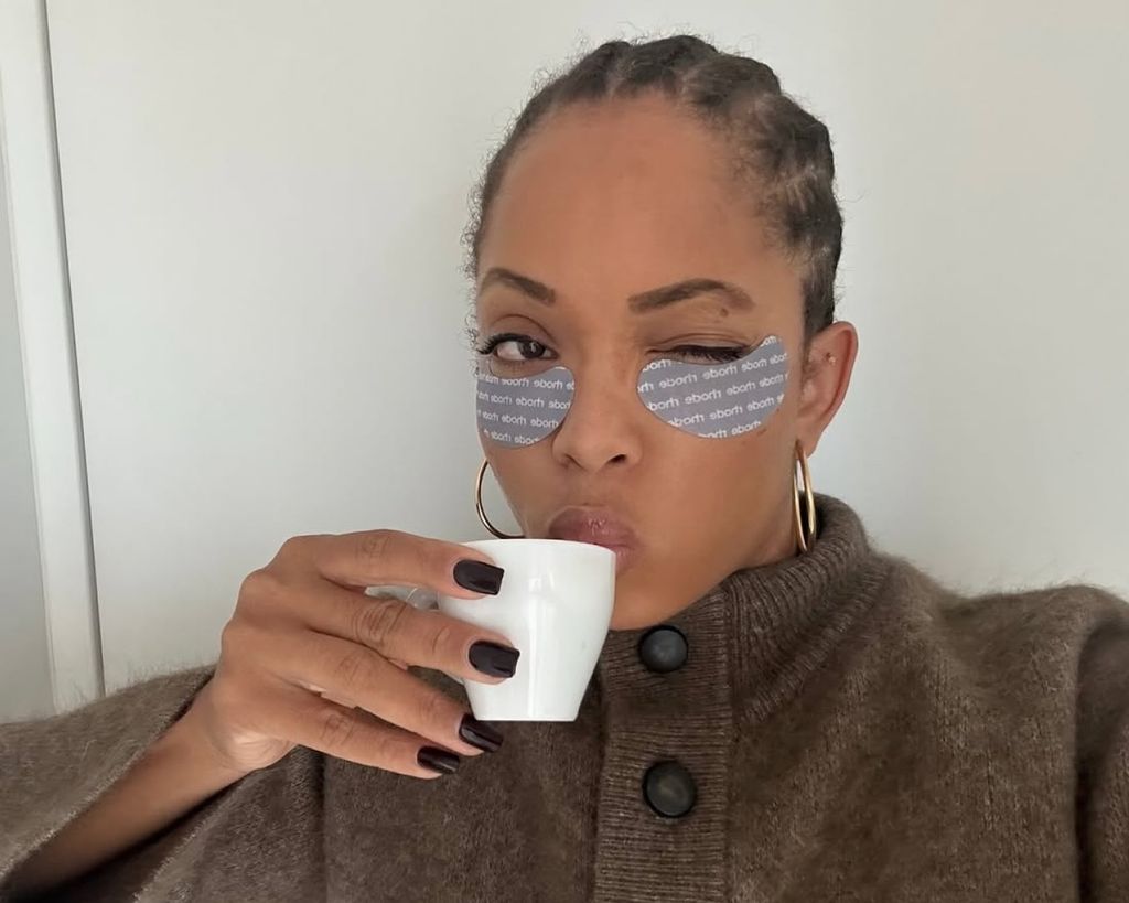 Woman drinking coffee and wearing rhode eye patches