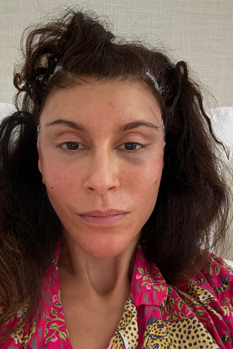 person with styled hair wearing a colorful blouse