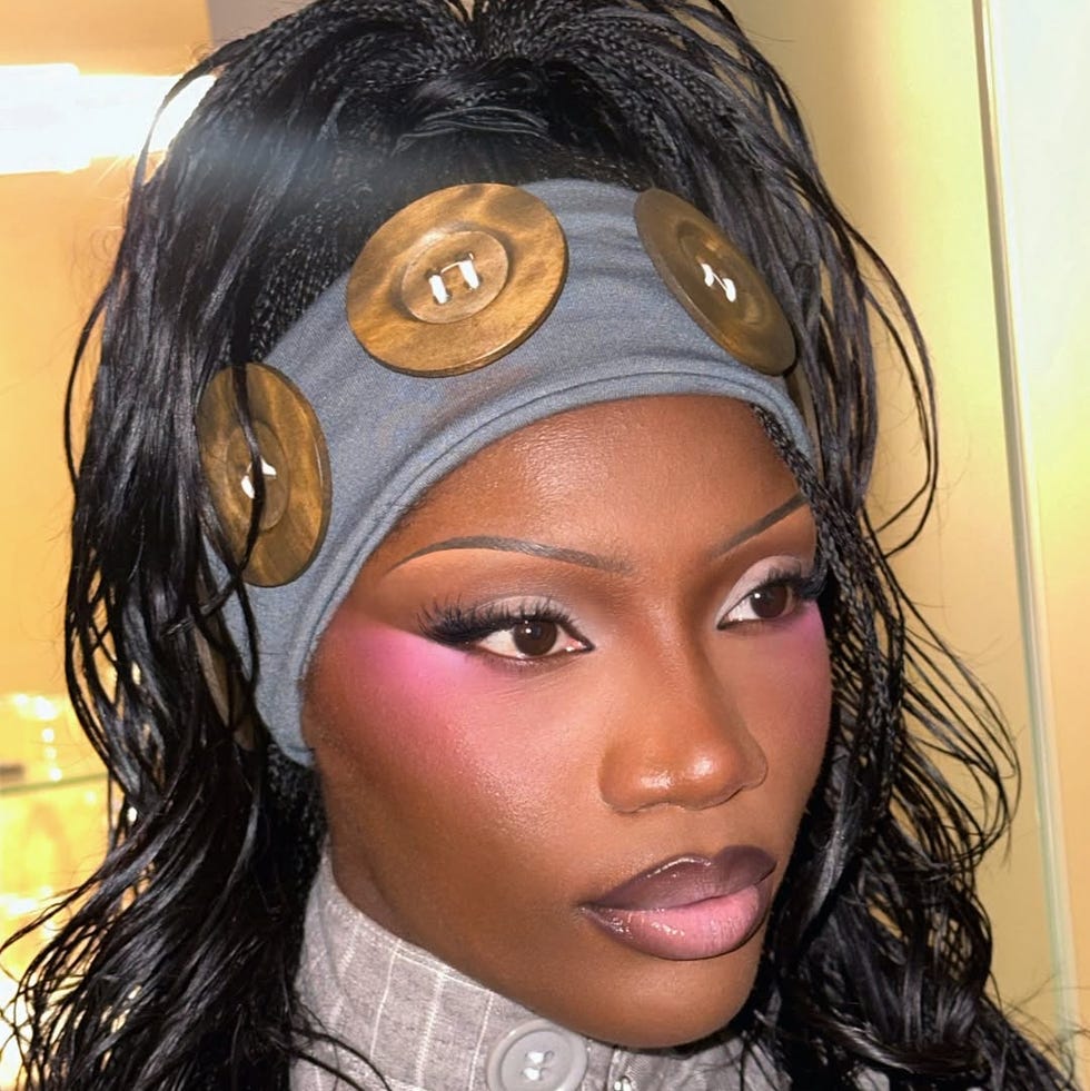 a person wearing a headband with large buttons and wavy hair