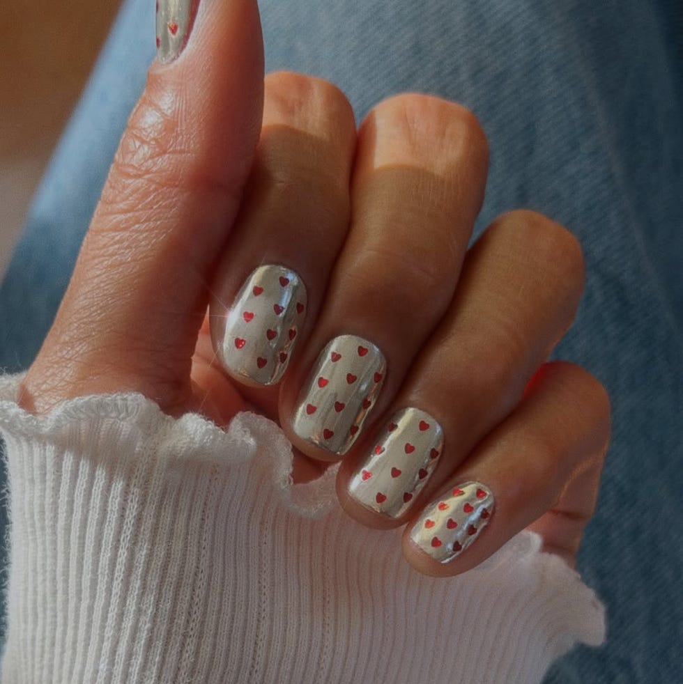hand displaying a nail design with heart patterns hand displaying a nail design with heart patterns