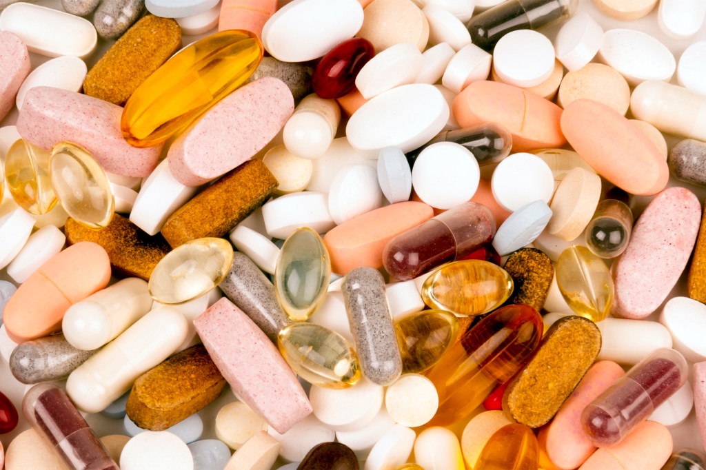 A large pile of various colorful pills, capsules, and tablets.
