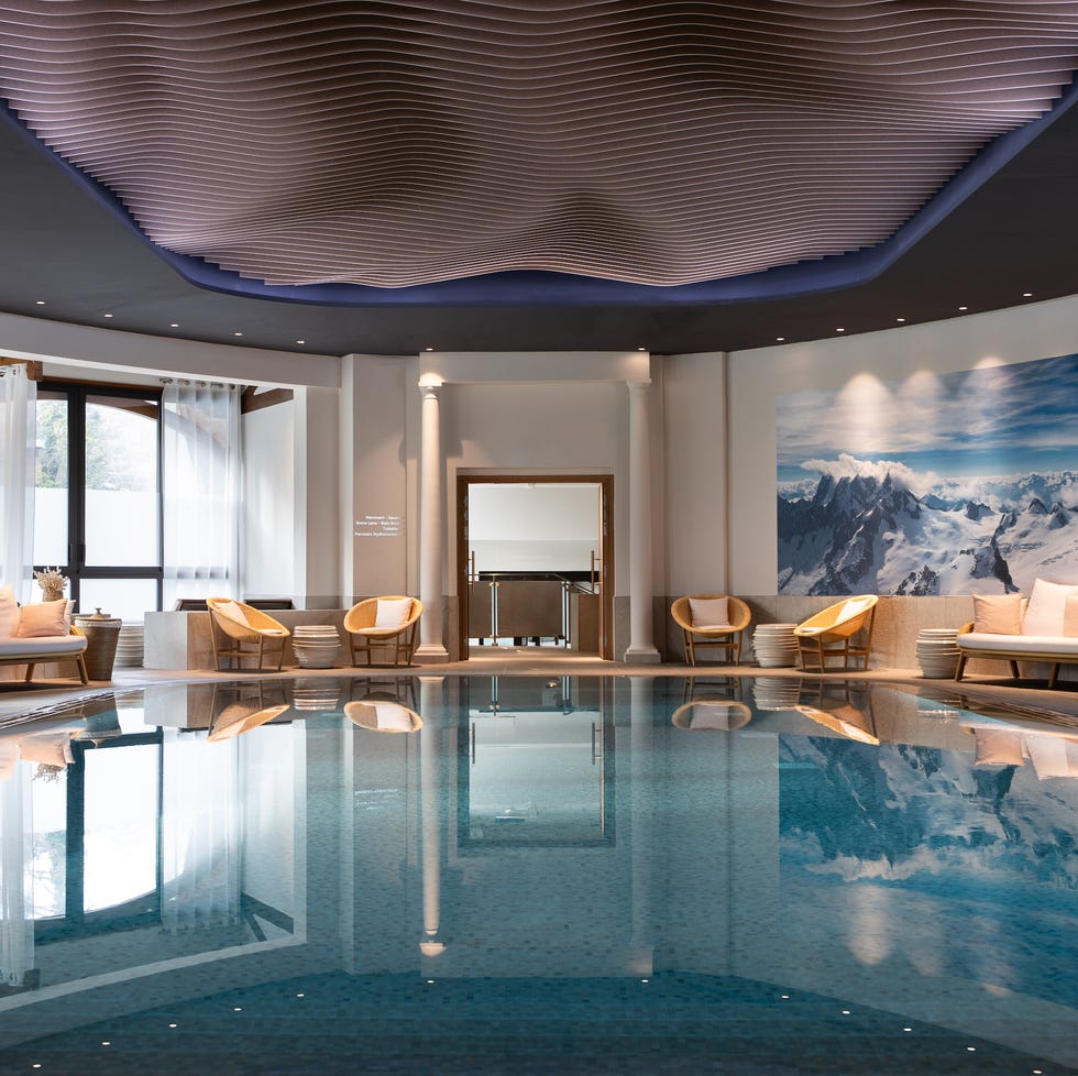 indoor swimming pool area with seating and mountain mural
