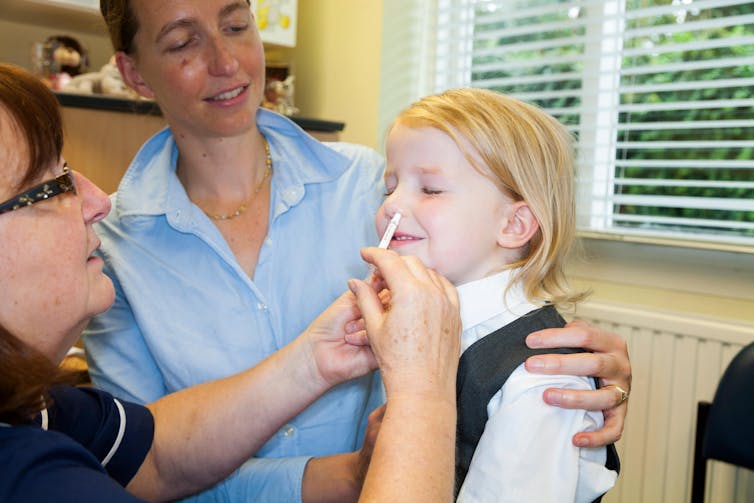 A young girl receives the flu vaccine.