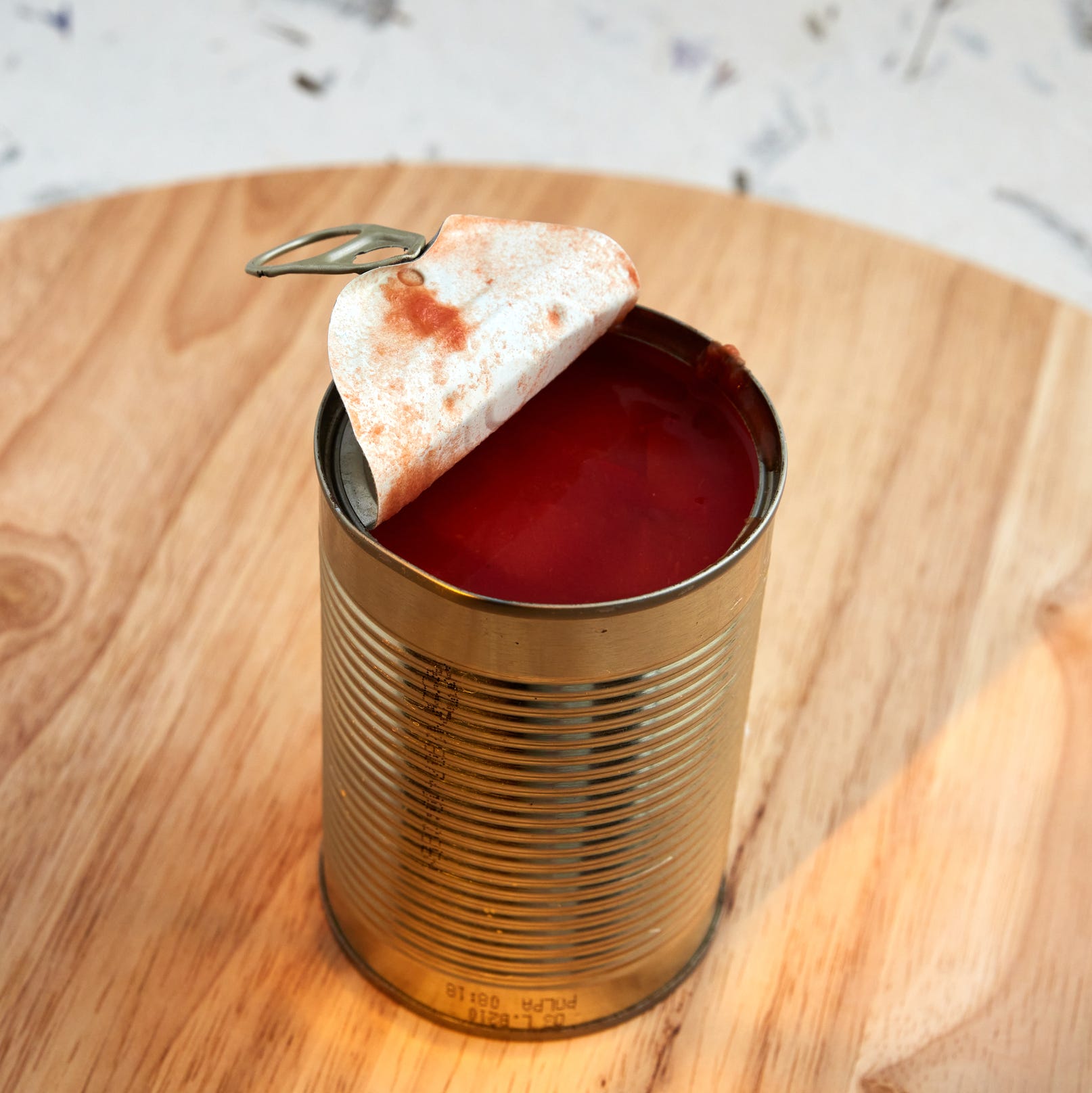 organic chopped tomatoes in tomate juice opened steel can wooden lazy susan decorative background light effect