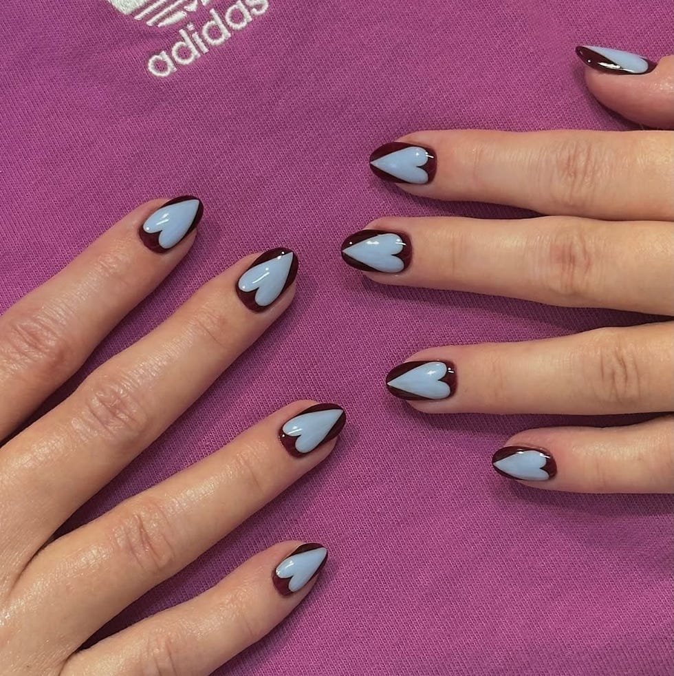 nail art featuring a blue and burgundy design on neatly manicured hands nail art featuring a blue and burgundy design on neatly manicured hands