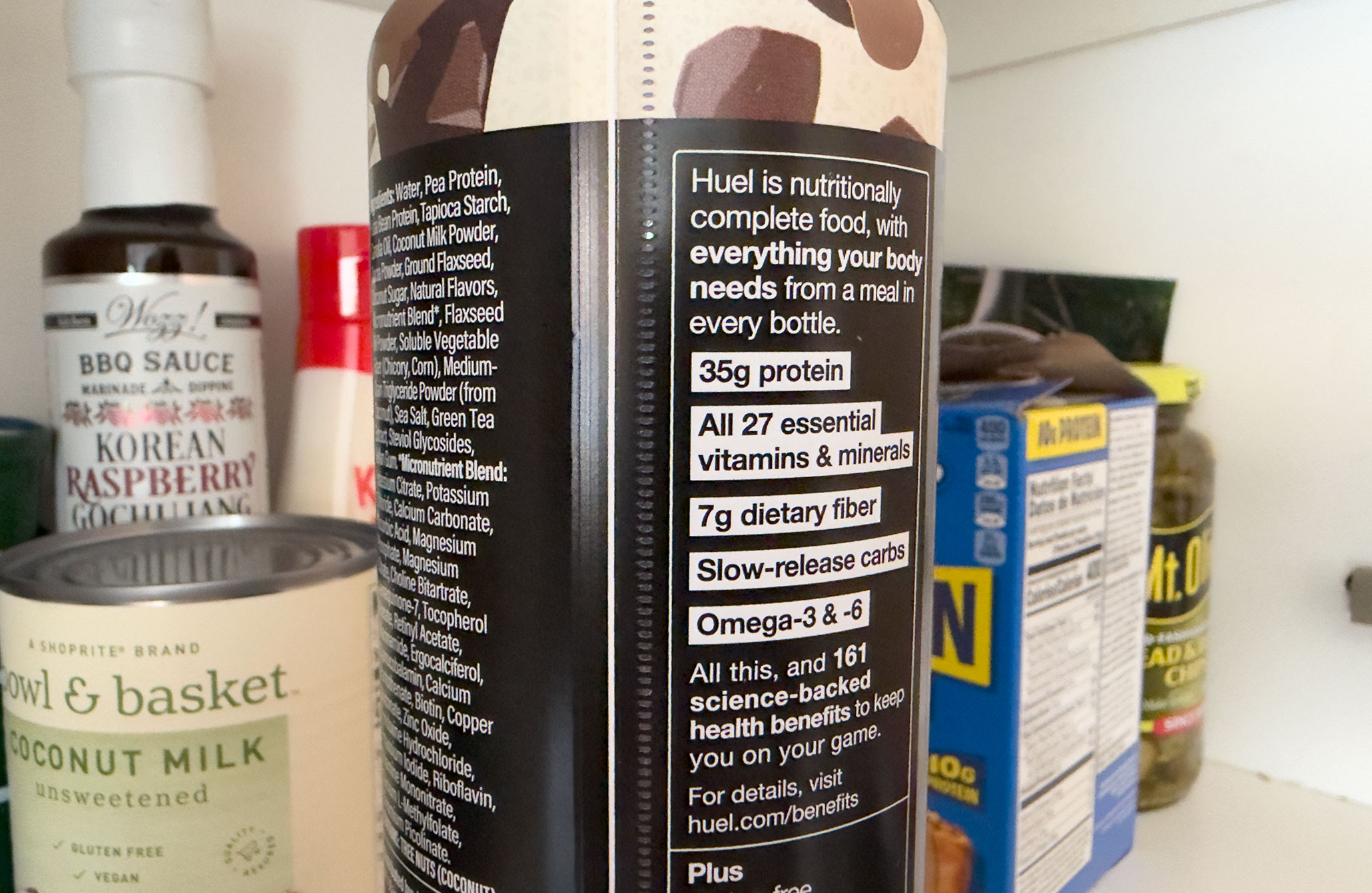Close up of a Huel bottle’s nutritional label that says ‘Huel is nutritionally complete food with everything your body needs from a meal in every bottle.’ It then lists the macronutrients and says ‘All this, and 161 science-backed health benefits to keep you on your game.’