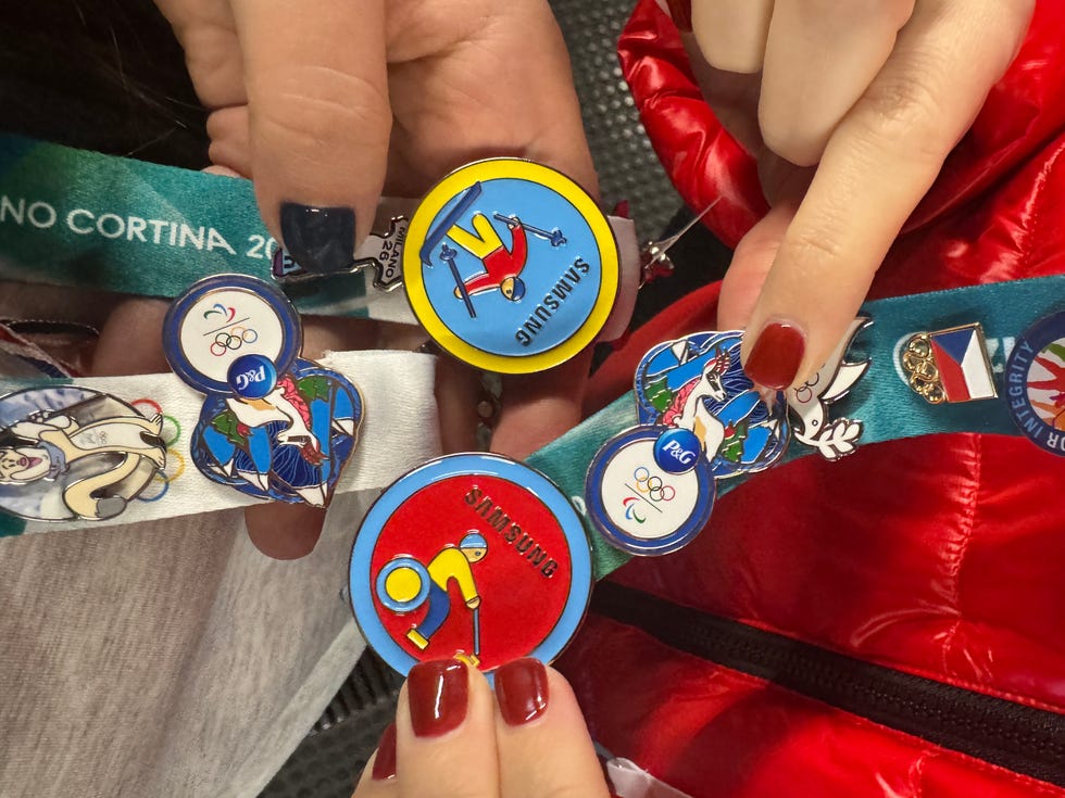olympic themed pins displayed by two people