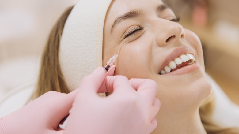 A woman getting a Botox injection around her eye