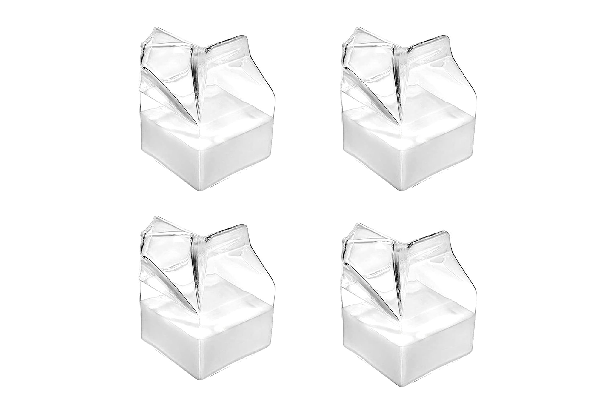 Four clear glass milk carton-shaped pitchers with white liquid inside.