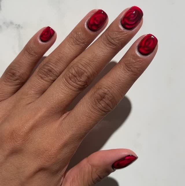 closeup of a hand with red rosethemed nail art closeup of a hand with red rosethemed nail art
