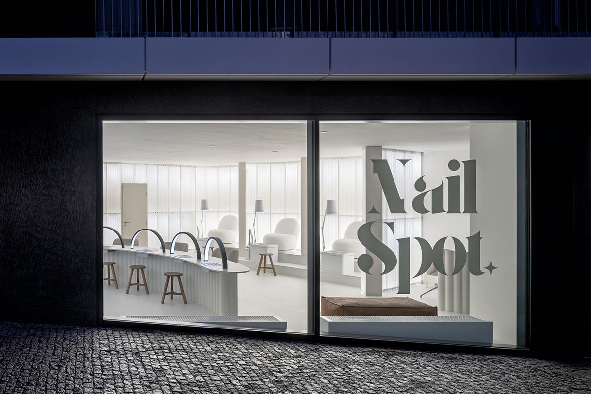 A beauty salon brings warm light with translucent partitions and tactile elements in Prague