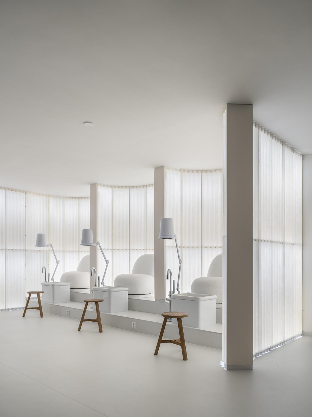 A beauty salon brings warm light with translucent partitions and tactile elements in Prague