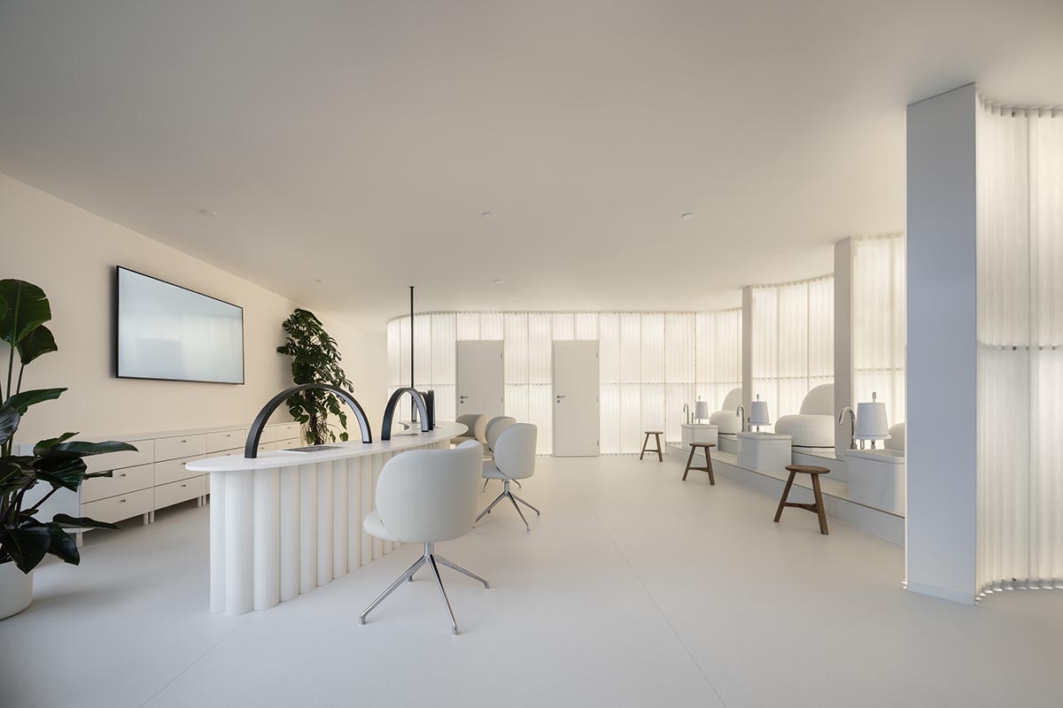 A beauty salon brings warm light with translucent partitions and tactile elements in Prague