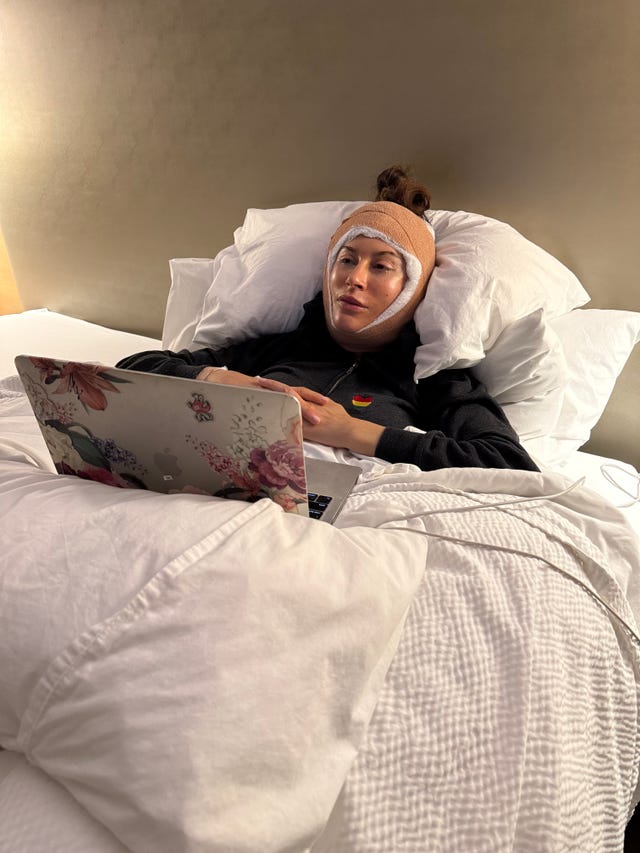 person using a laptop while lying in bed