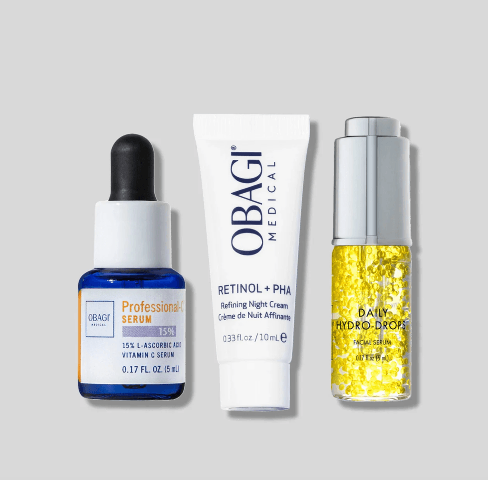 Three skincare products: a serum, night cream, and oil drops on a gray background.