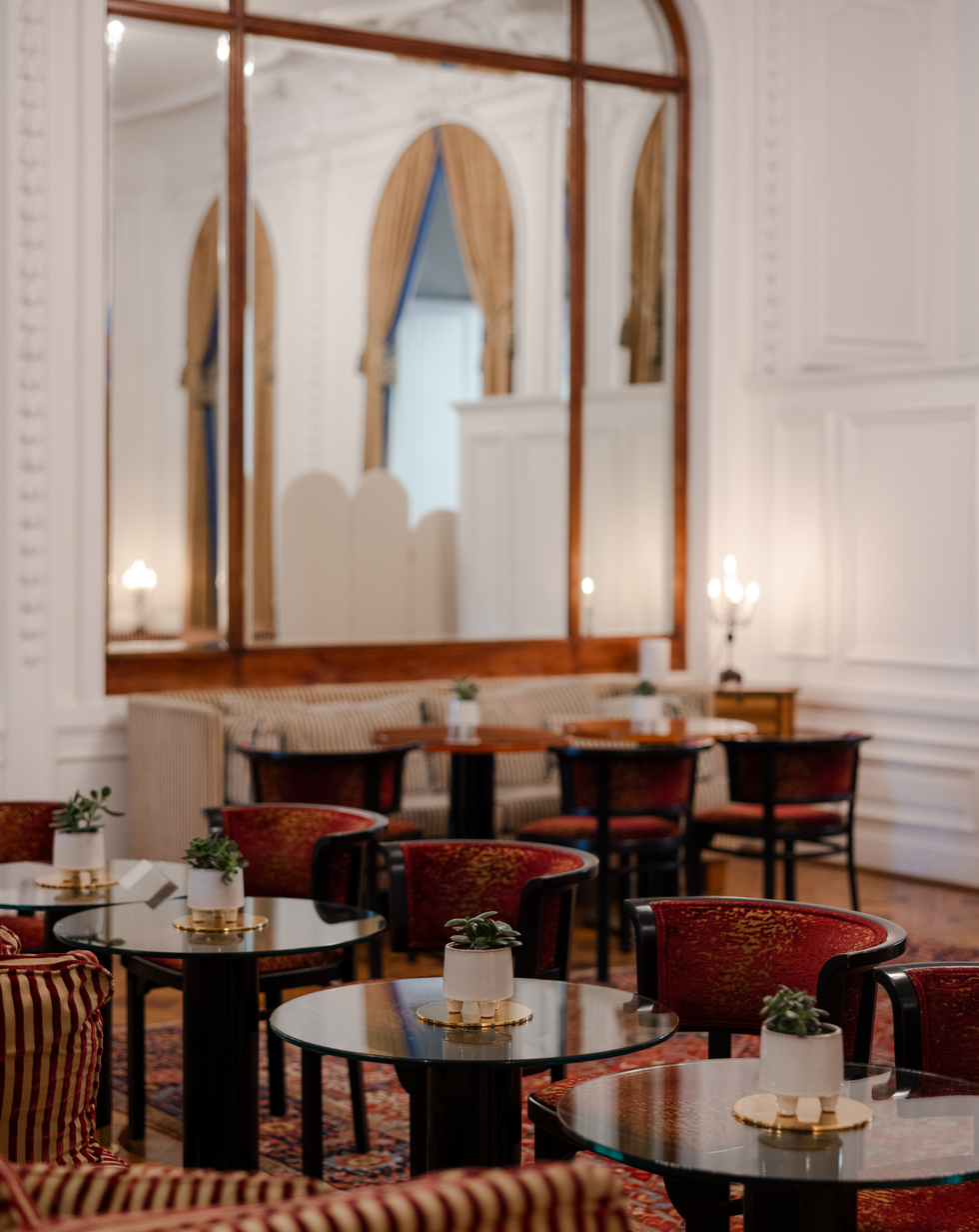 elegant cafe setting with tables chairs and decorative plants