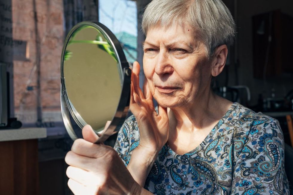 WOMAN LOOKING AT MIRROR