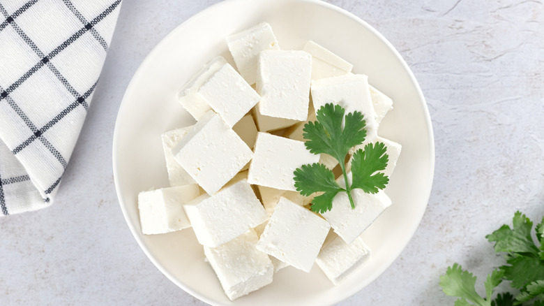 Blocks of white cheese in a bowl with parsley garnish
