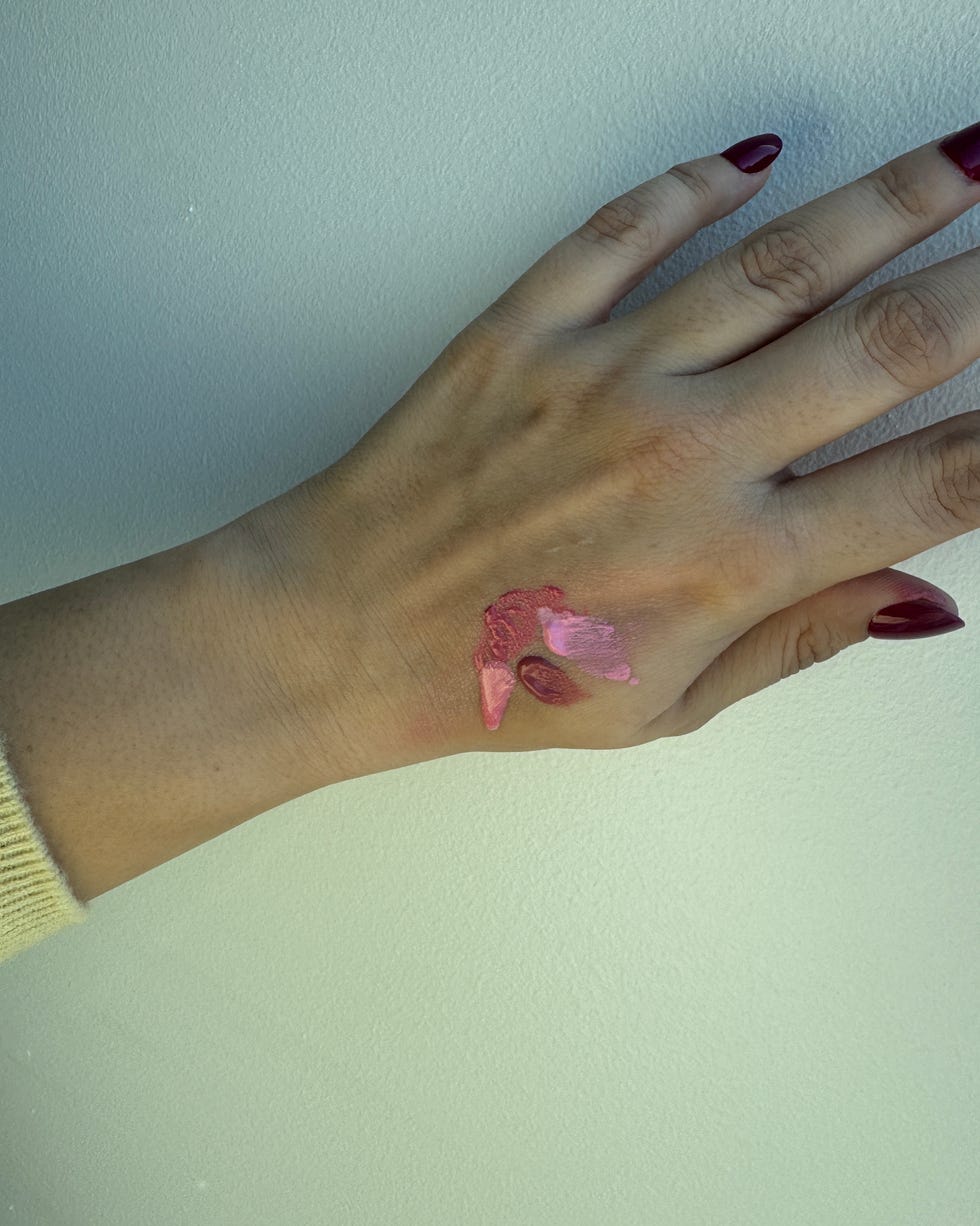 Hand with pink paint on the wrist.