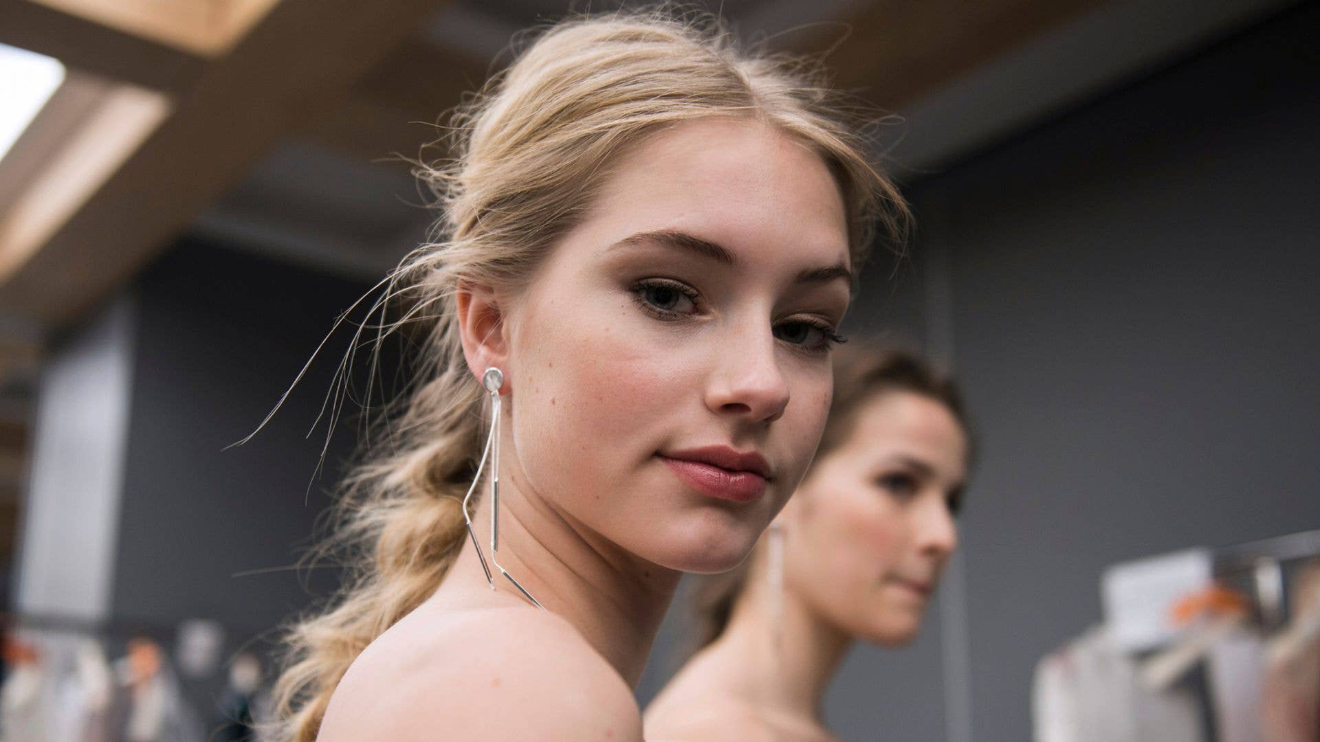 A model backstage at a wedding show with a French plait
