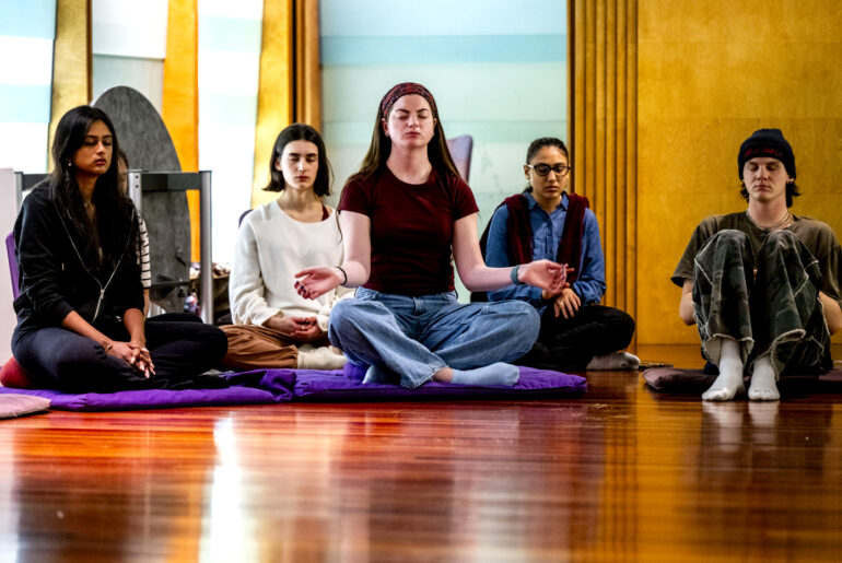 Northeastern university students sit and practice meditation during Wellness Week 2026