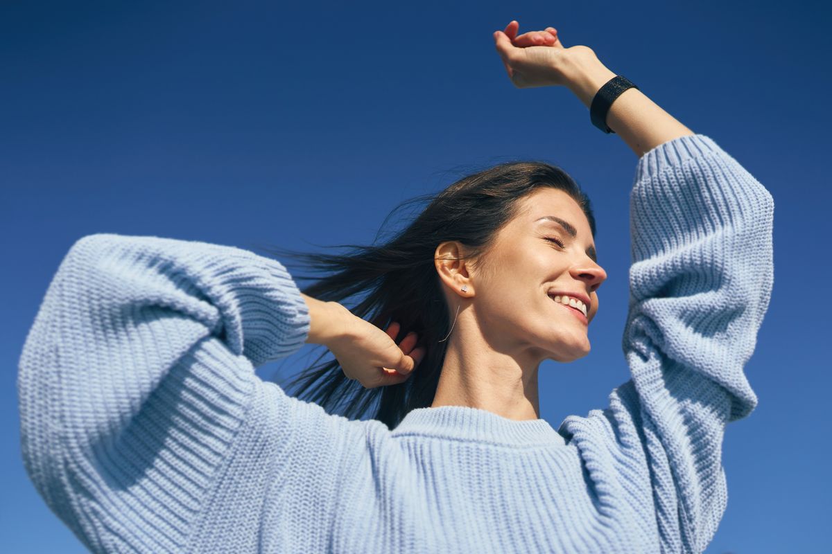Happy woman enjoying blue sky feeling freedom and happiness