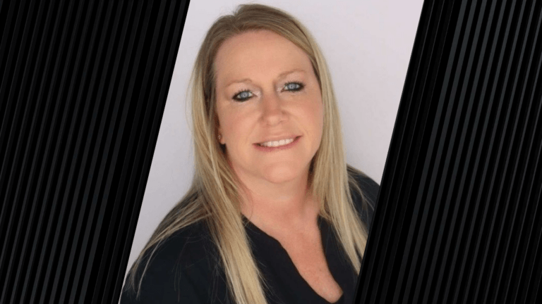 Portrait of a woman with blonde hair in front of a neutral background