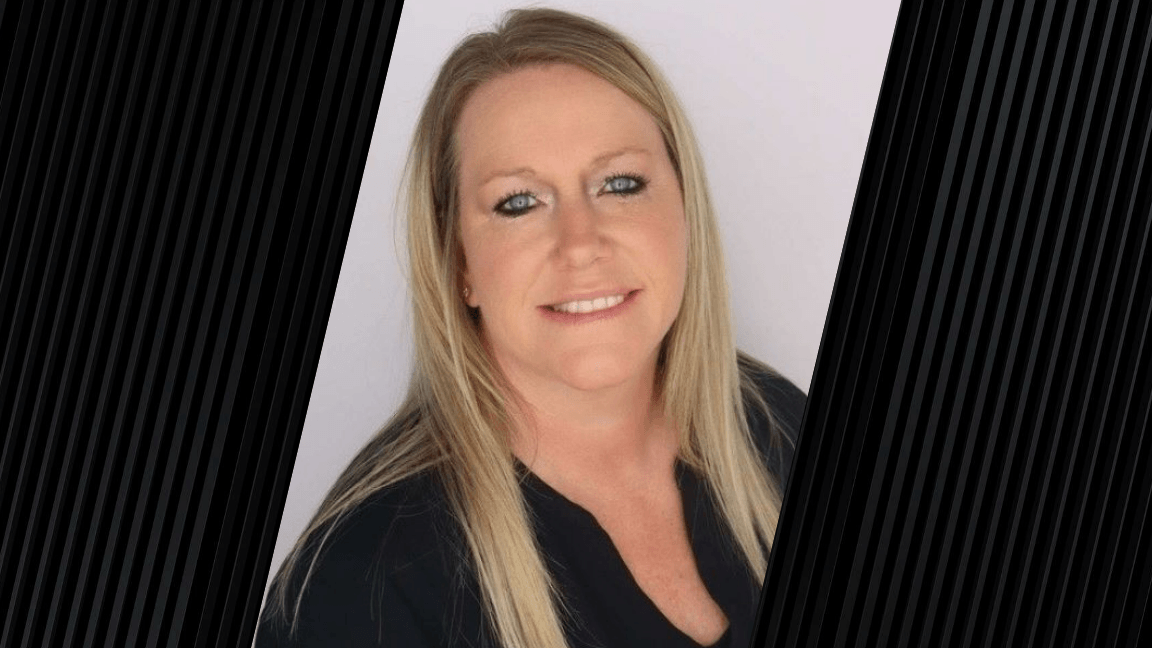 Portrait of a woman with blonde hair in front of a neutral background