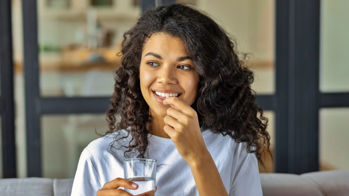 Young woman taking vitamins