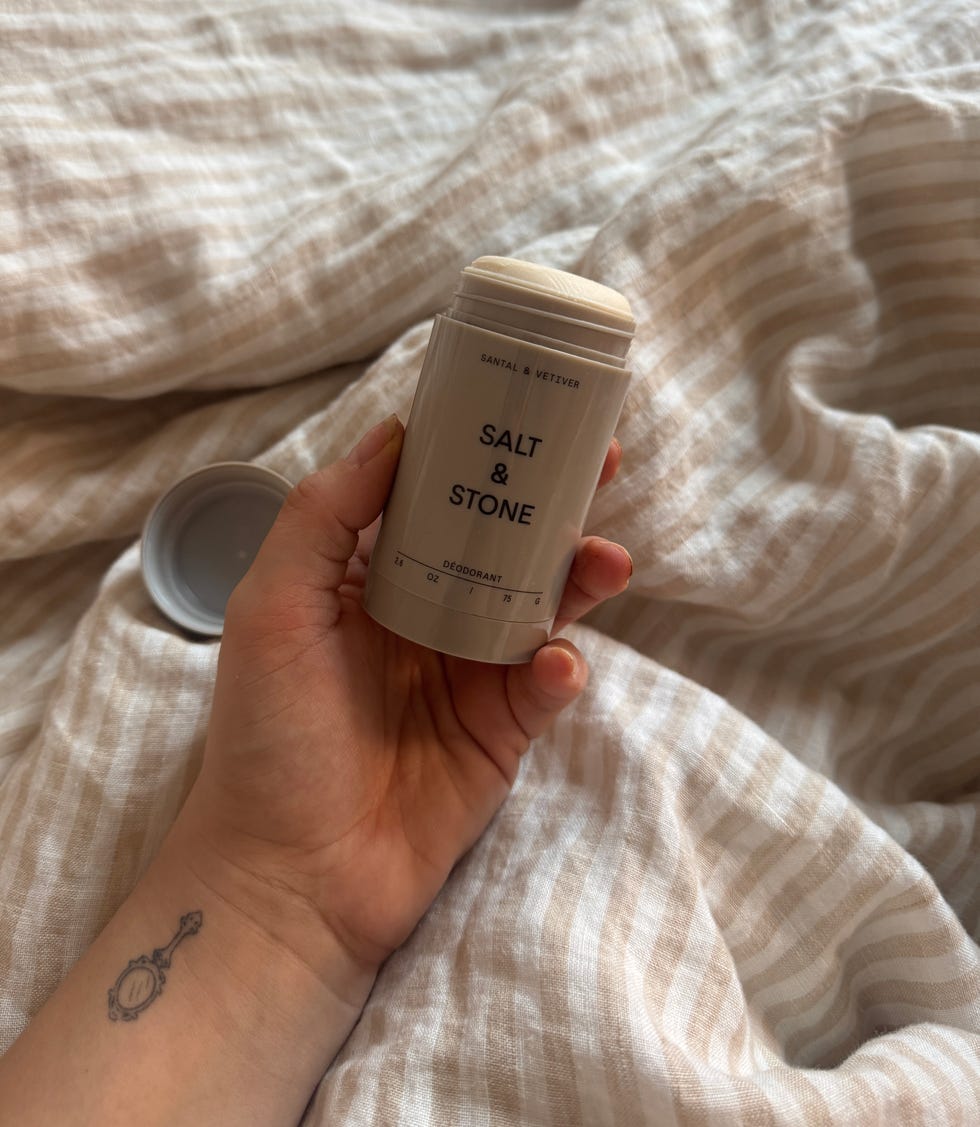 Deodorant container held above a soft, textured fabric.