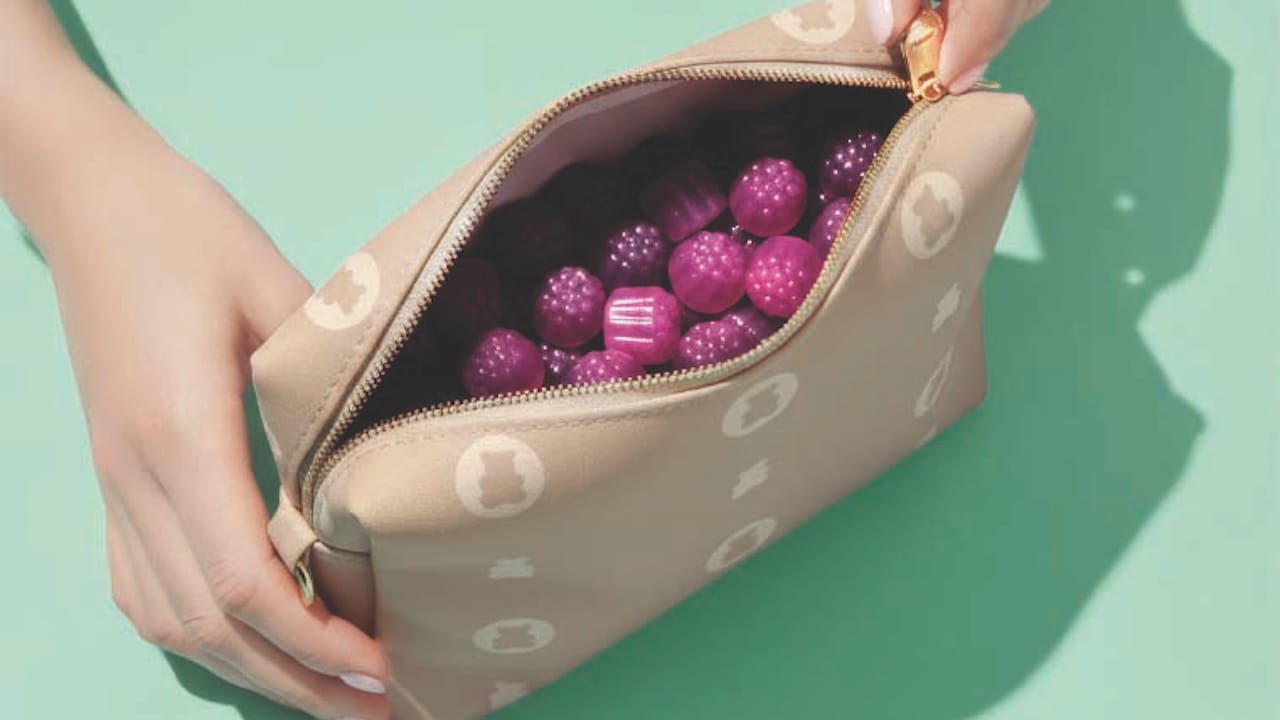 A woman’s hands unzip a pouch filled with gummy dietary supplements A woman’s hands unzip a pouch filled with gummy dietary supplements