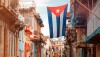 Cuban flags, people and aged buildings in Old Havana_Photo by kmiragaya via AdobeStock_274103301.jpg
