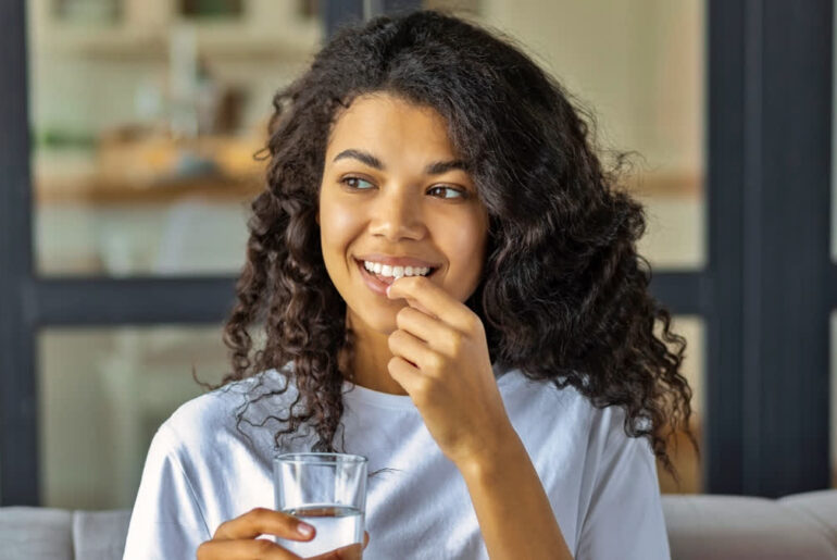 Young woman taking vitamins