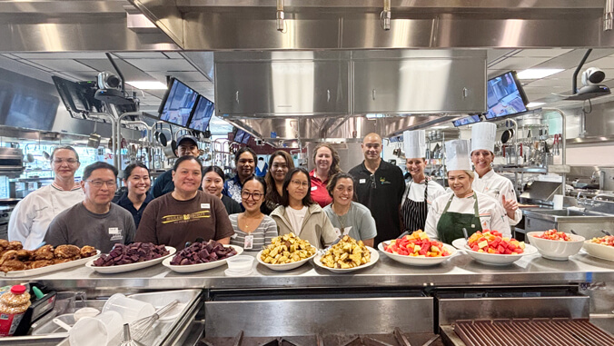 Smiling people in a kitchen with food