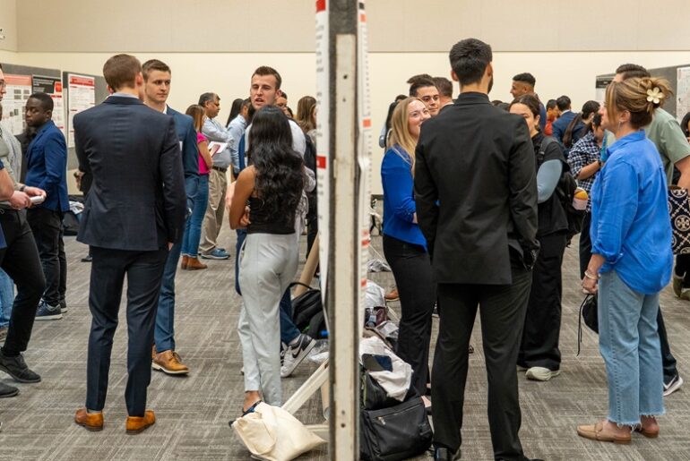 students stand and converse at an event