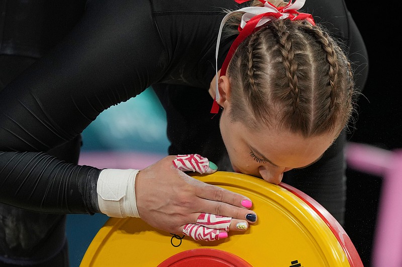 FILE - Weronika Zielinska of Poland kisses the weight as she competes during the women's 81kg weightlifting event, at the 2024 Summer Olympics, Saturday, Aug. 10, 2024, in Paris, France. (AP Photo/Kin Cheung,File)