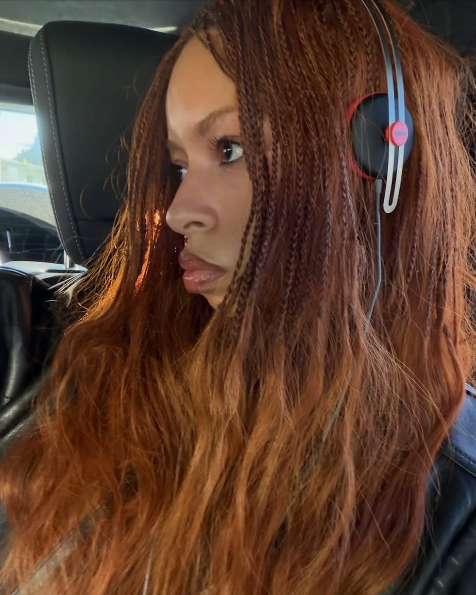 Person with long, wavy hair wearing headphones inside a vehicle. Person with long, wavy hair wearing headphones inside a vehicle.