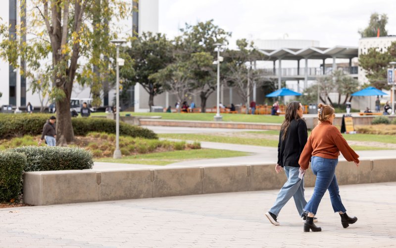 Two people walk on the Cal State Fullerton campus