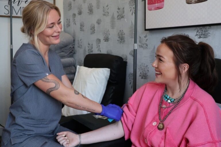 A nurse and patient smile and talk.
