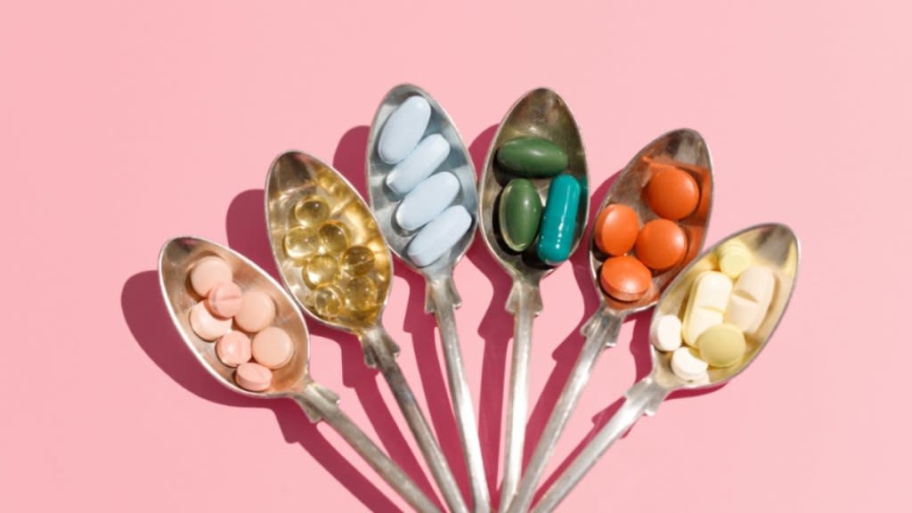 An assemblage of various arthritis supplements in vibrant hues arranged in spoons