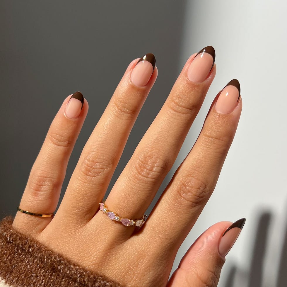 Hand with elegantly manicured nails and rings.