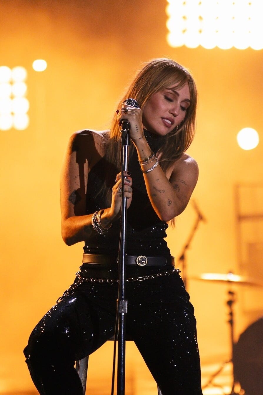 Singer performing on stage with a microphone.